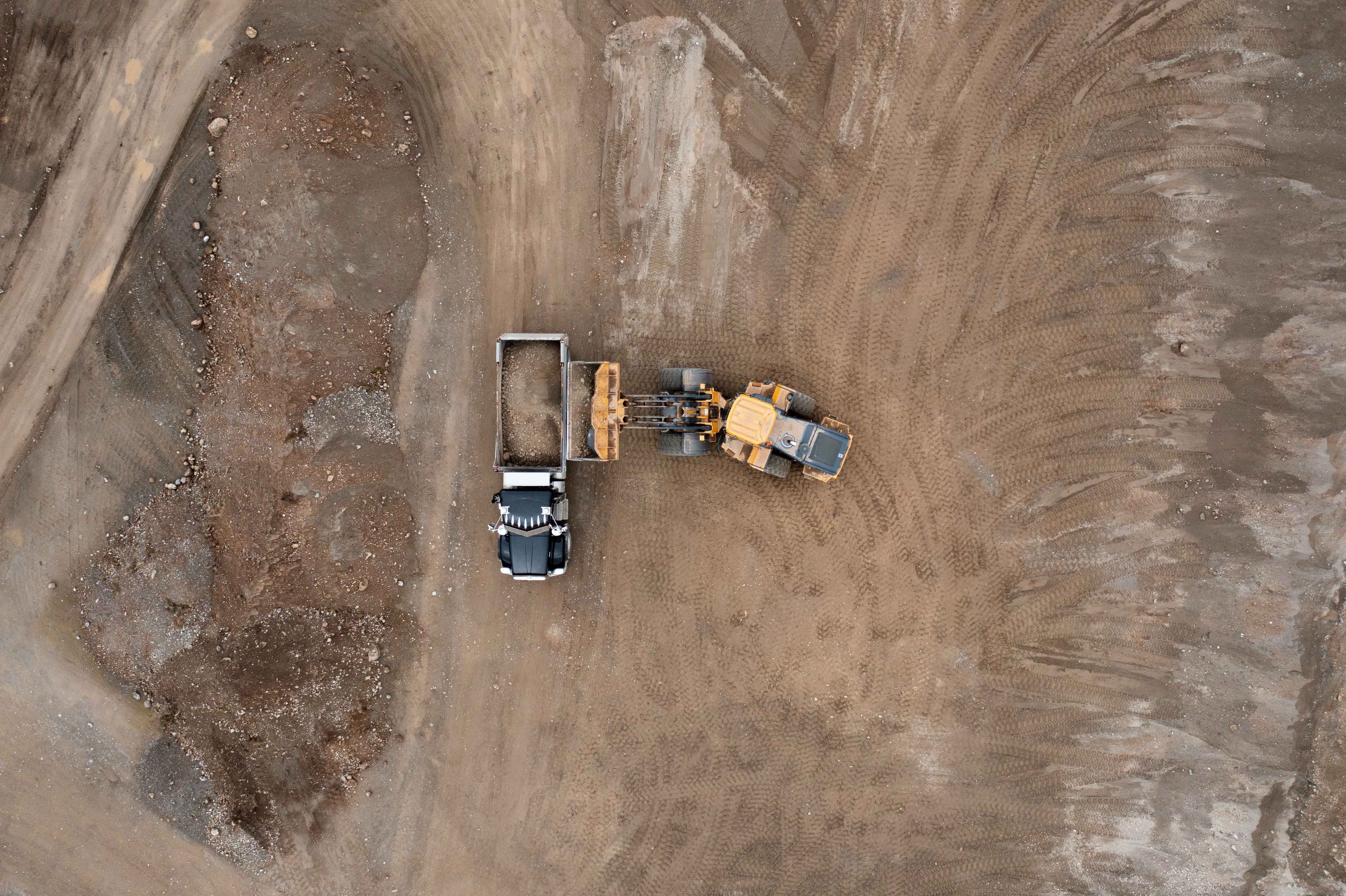 A birds eye view of heavy equipment on a bare construction site