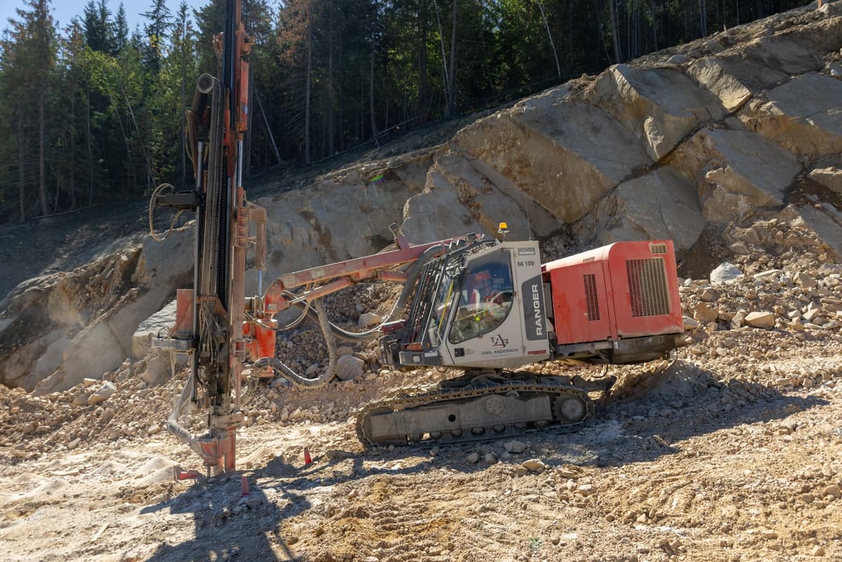 Equipment drilling into a cleared rock area